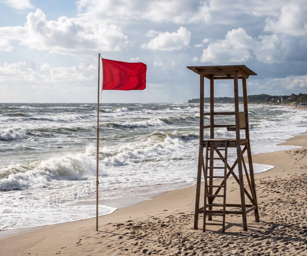 Czerwona flaga na plaży obok wieży ratowniczej. O zakazie kąpieli w Mielnie przeczytasz na SE Szczecin.