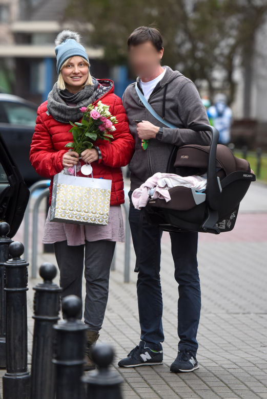 Joanna Moro z mężem i dzieckiem wychodzą po porodzie ze szpitala
