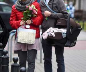 Joanna Moro z mężem i dzieckiem wychodzą po porodzie ze szpitala