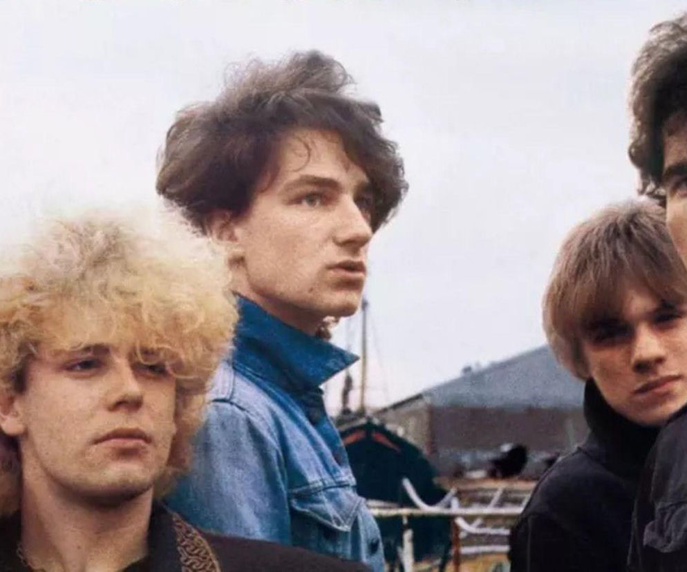 Młodzi muzycy zespołu U2 na tle portu w Dublinie. O historii albumu October przeczytasz na EskaRock.