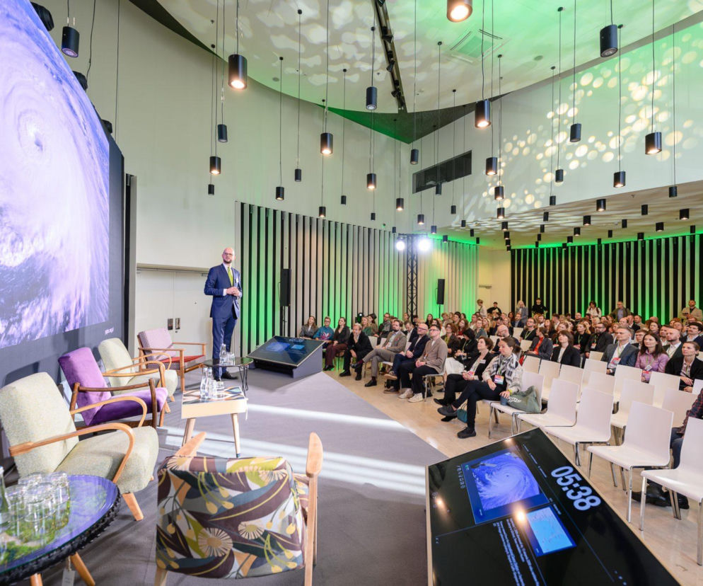 Bartosz Marcol przemawia na scenie PLGBC Green Building Summit przed publicznością. O wydarzeniu przeczytasz na Architektura.
