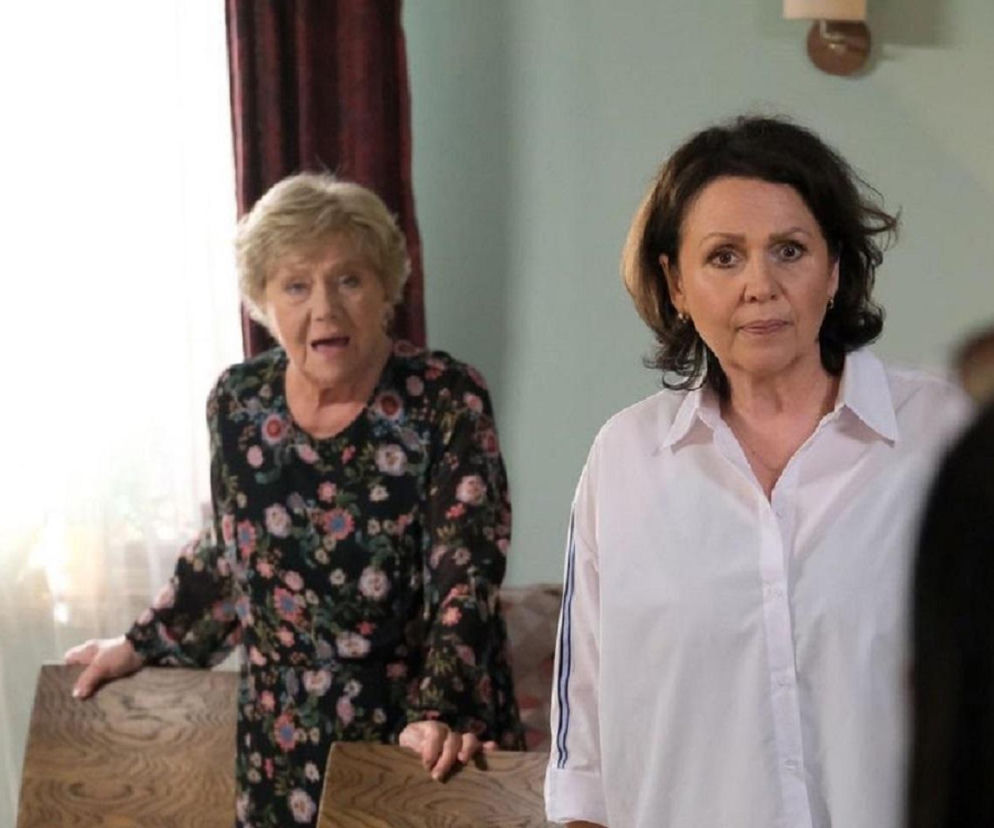 Zofia Kisielowa, w którą wciela się Małgorzata Rożniatowska, w ciemnej sukience w kwiaty oraz Małgorzata Pieńkowska jako Marysia Rogowska w białej koszuli, patrzą zaskoczone na kogoś poza kadrem. Artykuł na Super Seriale opisuje zmiany w obsadzie M jak miłość.