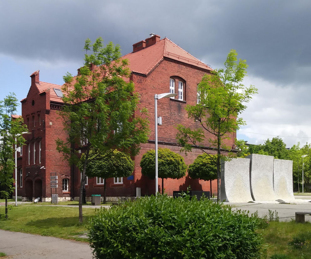 Budynek z czerwonej cegły i Pomnik Powstańców Śląskich w Radzionkowie. O historii miasta przeczytasz na Eska Śląskie.