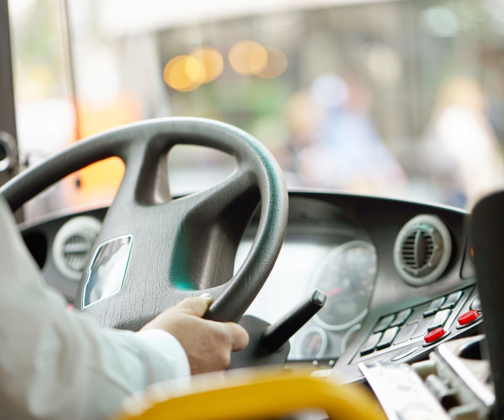 Dłoń kierowcy trzymająca kierownicę autobusu podczas jazdy. O wyroku dla oprawcy dzieci przeczytasz na SE.