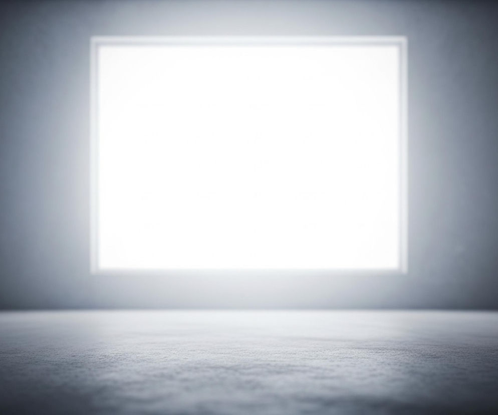 Centralnie umiejscowiony, jasny prostokąt dominuje obraz, emitując intensywne białe światło. Otacza go cienka, biała ramka, a całość kontrastuje z ciemnym, szarym tłem, które blednie ku górze i rogom. Przed prostokątem rozciąga się ciemnoszara, teksturalna powierzchnia podłogi, której drobne, poziome nierówności są lekko widoczne, a jej odcień stopniowo przechodzi w jaśniejszy w stronę źródła światła.