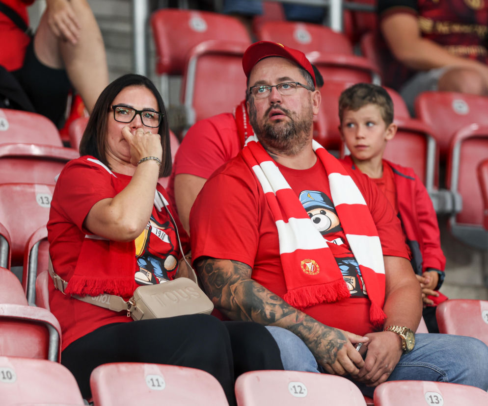 Kibice Widzewa Łódź w czerwonych koszulkach na trybunach stadionu. O meczu z Lechem Poznań przeczytasz na Eska Łódź.