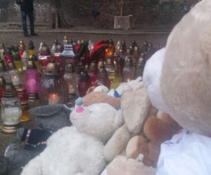 Przed blokiem, w którym zginęła kobieta i dwoje dzieci palą się znicze