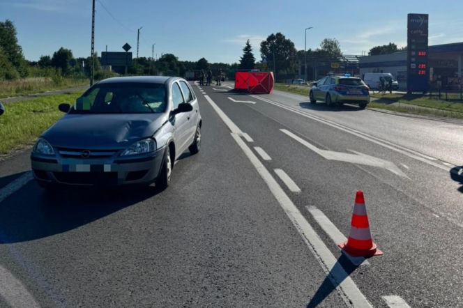Srebrny Opel z uszkodzoną maską na drodze, w tle parawan i policja. O tragedii w Zarzeczu przeczytasz na Eska Rzeszów.
