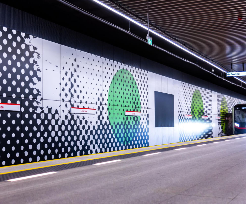 Peron stacji metra Zacisze linii M2 z grafikami na ścianach i pociągiem. O metrze do Ursusa czytaj w Architektura.