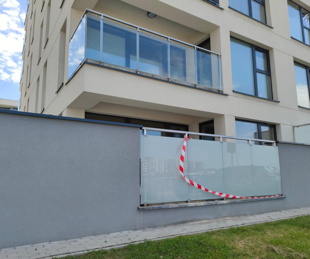 Blok mieszkalny z oszklonymi balkonami. Miejsce wypadku dziecka zabezpiecza taśma. O sprawie przeczytasz na SE Białystok.
