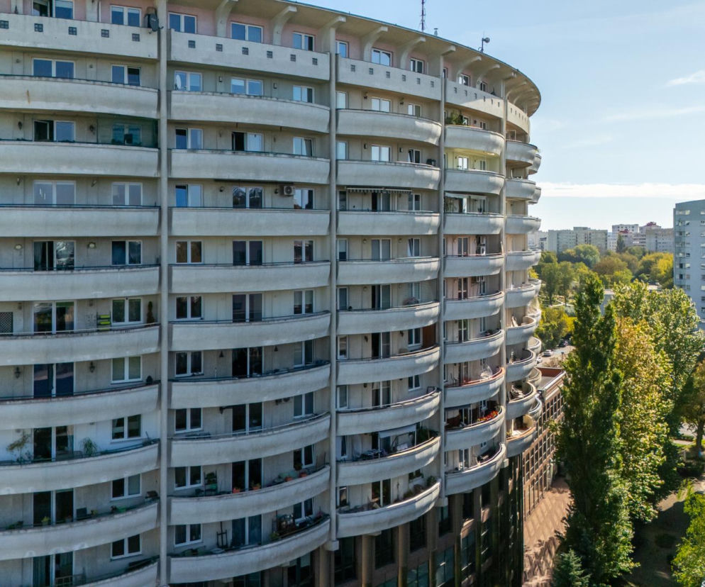 Półkolisty budynek Colosseum w Warszawie z rzędami jasnych balkonów. O tej architekturze przeczytasz w serwisie Architektura.