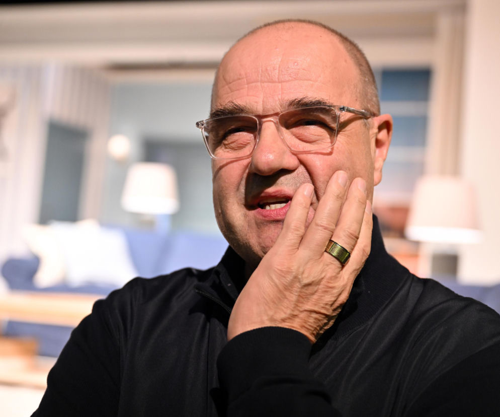 Aktor Cezary Żak w okularach, trzymający dłoń przy twarzy. O jego reakcji na hejt przeczytasz na SE Polityka.