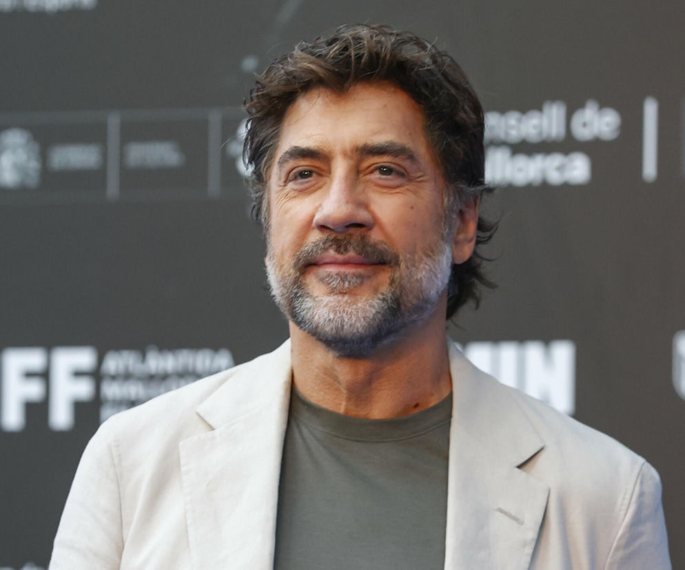 Aktor Javier Bardem w jasnej marynarce na tle logotypów. O jego rockowych inspiracjach przeczytasz na EskaRock.