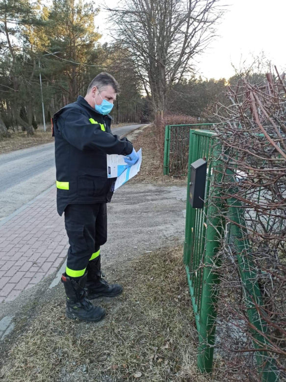 Strażacy z OSP dostarczają ulotki na temat szczepień do mieszkańców powiatu iławskiego