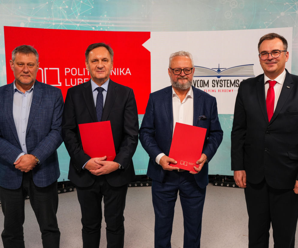 Czterech mężczyzn w garniturach trzymających czerwone teczki. O nowym kierunku studiów przeczytasz na Eska Lublin.