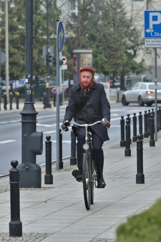 Maciej Gdula na rowerze. Chroni uszy przed chłodem