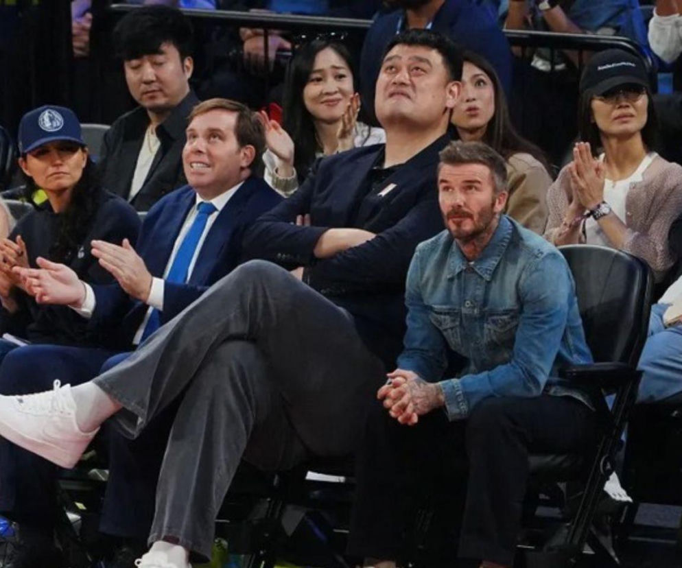 David Beckham siedzący obok znacznie wyższego Yao Minga na trybunach. O ich spotkaniu przeczytasz na SE.