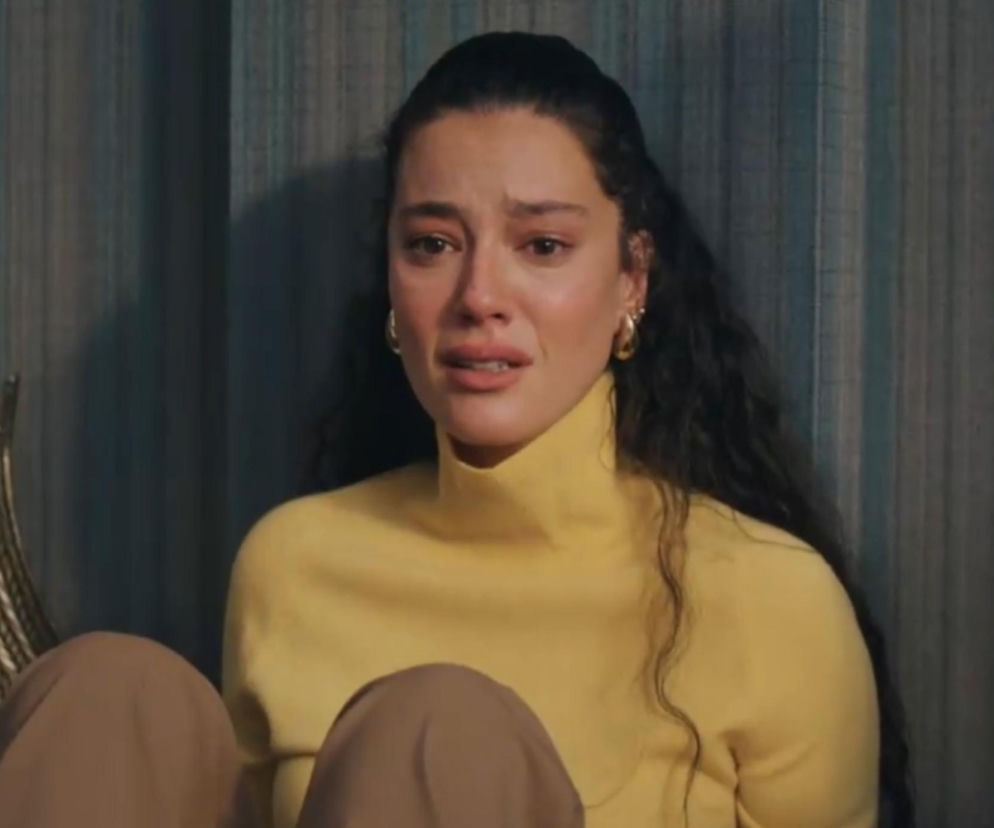 Afra Saraçoğlu jako Seyran w serialu „Złoty chłopak”, na zdjęciu postać w żółtym golfie i brązowych spodniach, z zapłakaną twarzą, smutek i rozczarowanie malują się na jej twarzy. Więcej o tym na Super Seriale.