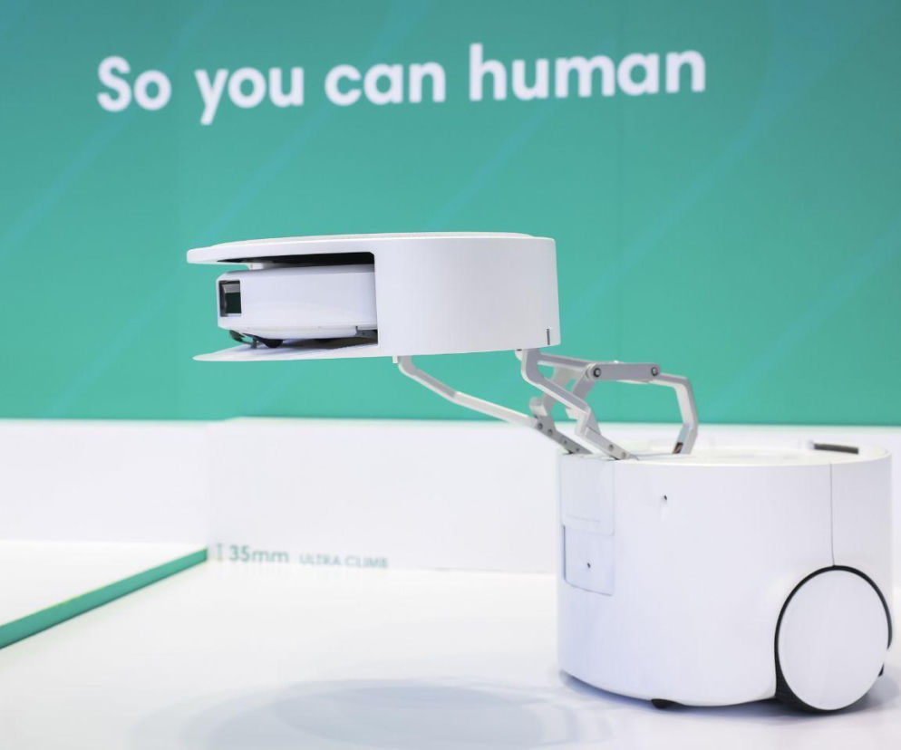 Biały robot Roomba Duo z mechanicznym ramieniem trzymającym mniejsze urządzenie. O nowościach z IFA 2026 przeczytasz na Eska.