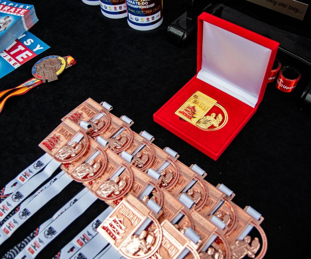 Złoty medal w czerwonym pudełku oraz szereg brązowych medali na stole. O Narodowym Dniu Sportu przeczytasz na Eska.
