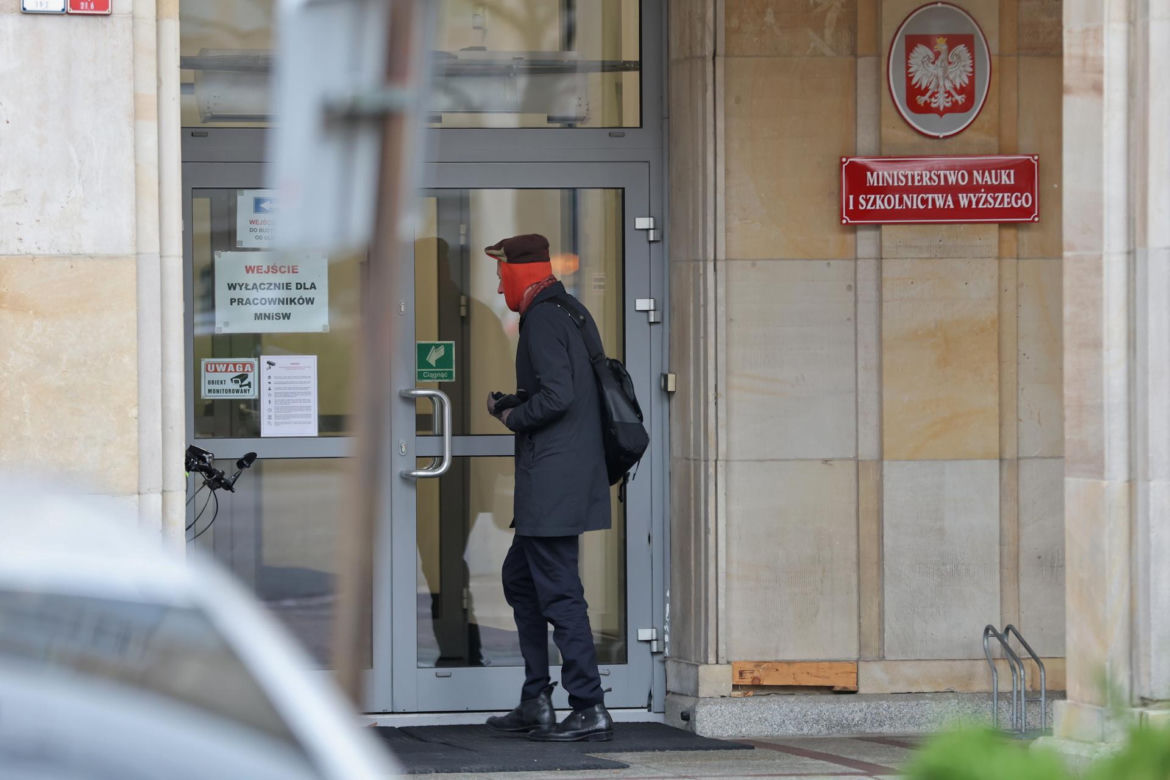 Maciej Gdula na rowerze. Chroni uszy przed chłodem