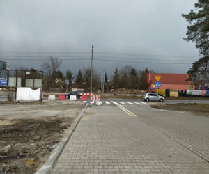 Energetyczny słup na środku wjazdu do sklepu. Ludzie robią sobie przy nim zdjęcia