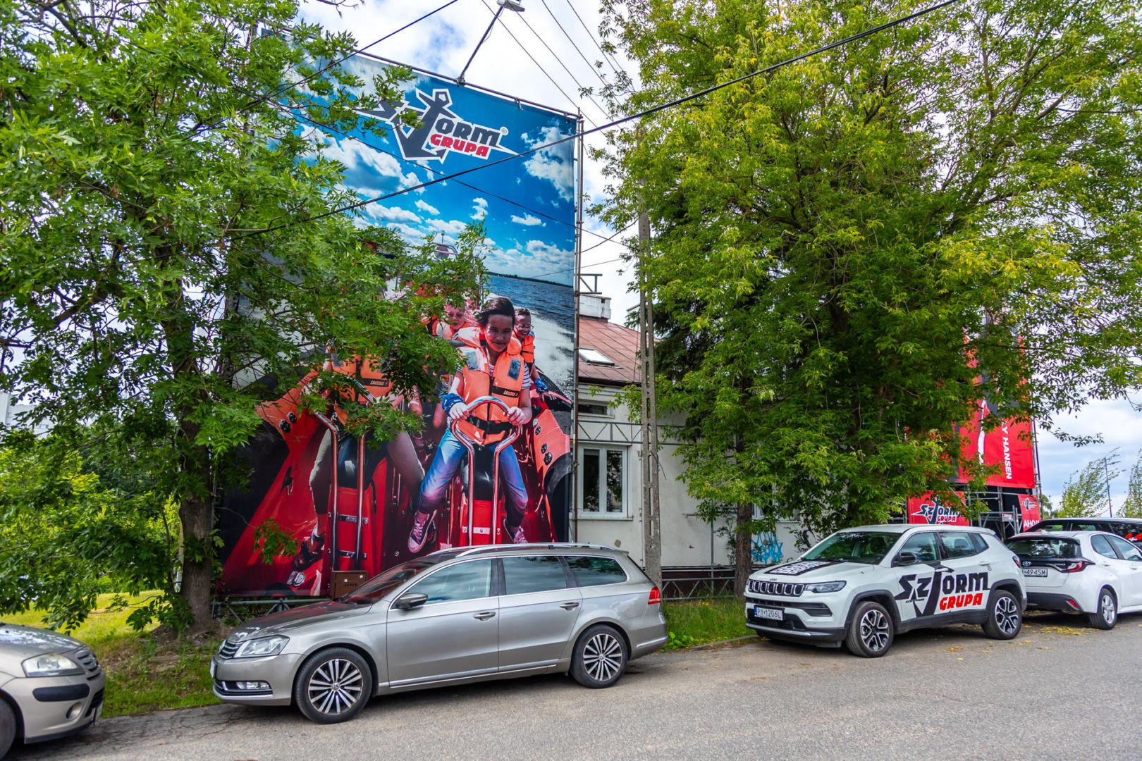 Otoczony reklamami dom przy Dolinie Służewieckiej w Warszawie