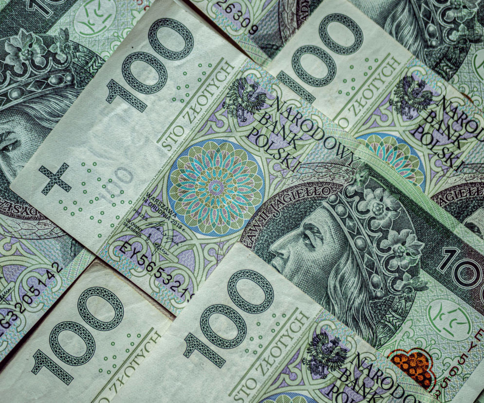 Banknoty o nominale 100 złotych rozłożone jeden na drugim. O rekordach w sektorze pożyczek przeczytasz na Eska.