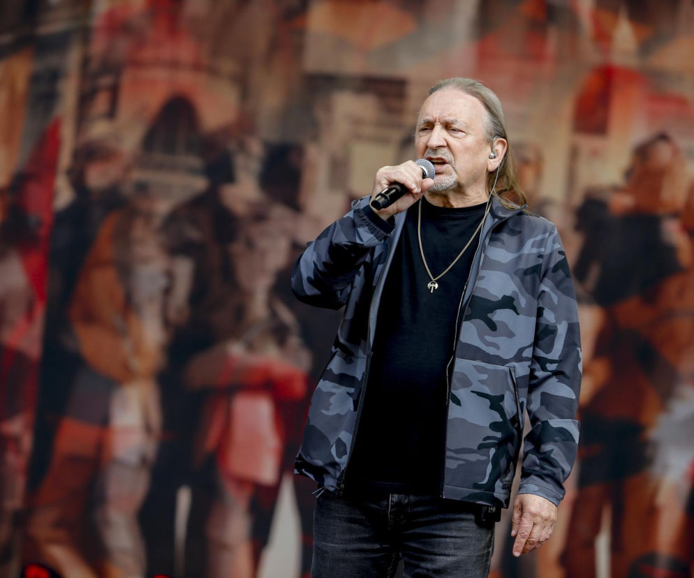 Marek Piekarczyk śpiewa do mikrofonu na scenie. O nowej edycji jego biografii przeczytasz na EskaRock.