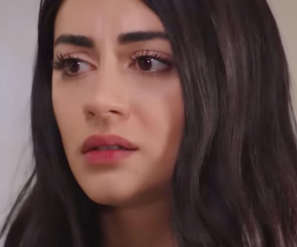 Twarz Hancer z tureckiego serialu Panna młoda z zatroskanym wyrazem, ciemne włosy opadają na ramiona. Ciemne oczy skierowane w lewo, subtelny makijaż, różowe usta. Więcej o losach bohaterów przeczytasz na Super Seriale.