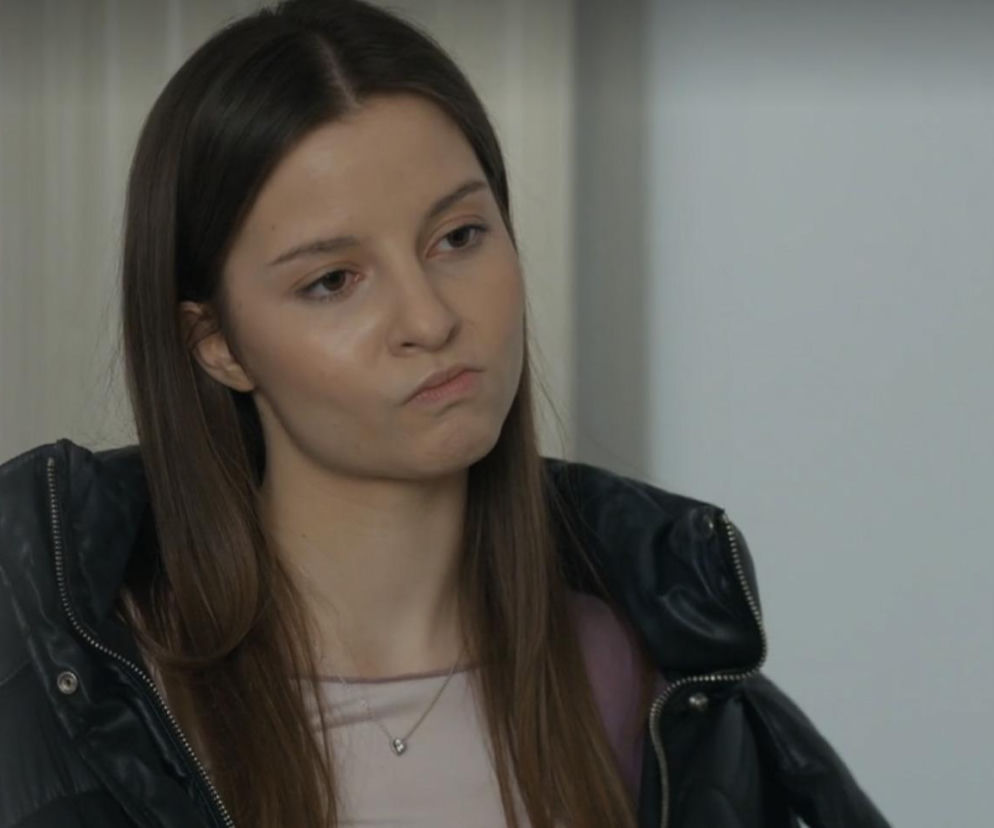 Zbliżenie na Ewę (Gabriela Ziembicka) z serialu Barwy szczęścia w czarnej kurtce, wyraźnie zaniepokojoną i zamyśloną, z pomarszczonym czołem, odzwierciedlające jej wątpliwości dotyczące małżeństwa. Więcej o losach bohaterów na portalu Super Seriale.