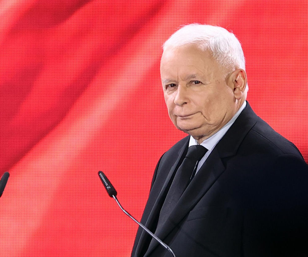 Prezes PiS Jarosław Kaczyński na tle biało-czerwonej flagi. O problemach finansowych partii przeczytasz na Eska.