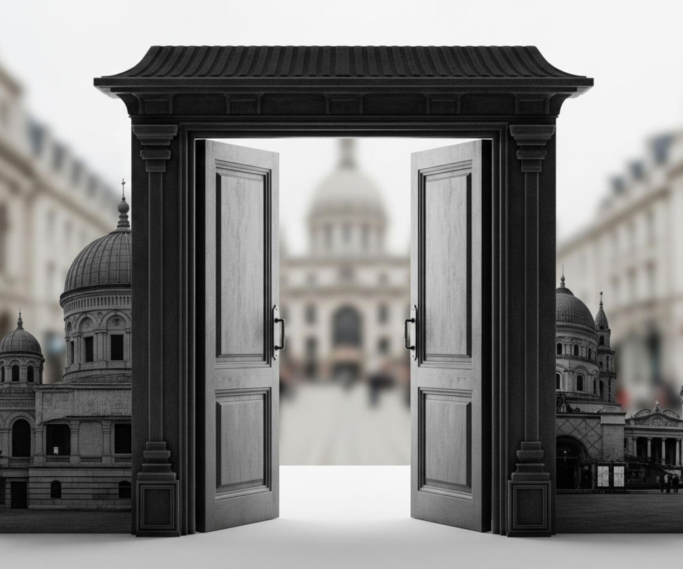 Otwarty, ciemnoszary portal w stylu klasycznym stoi na białej płaszczyźnie, ukazując przez swoje szeroko otwarte, kasetonowe drzwi rozmyte, miejskie tło z kopułą katedry w centralnym punkcie. Z boków portalu, na tej samej białej płaszczyźnie, wyrastają fragmenty czarno-białych budynków o architekturze sakralnej z kopułami i wieżami, które łączą się z rozmazanym tłem. Lewy fragment przedstawia kopułowy budynek w widoku z boku, natomiast prawy ukazuje fasadę z kolumnadą i wysoką wieżą zwieńczoną iglicą, przed którą stoją niewyraźne sylwetki ludzi. Całość utrzymana jest w stonowanych odcieniach szarości i bieli, z subtelnym rozmyciem tła, co tworzy wrażenie głębi.