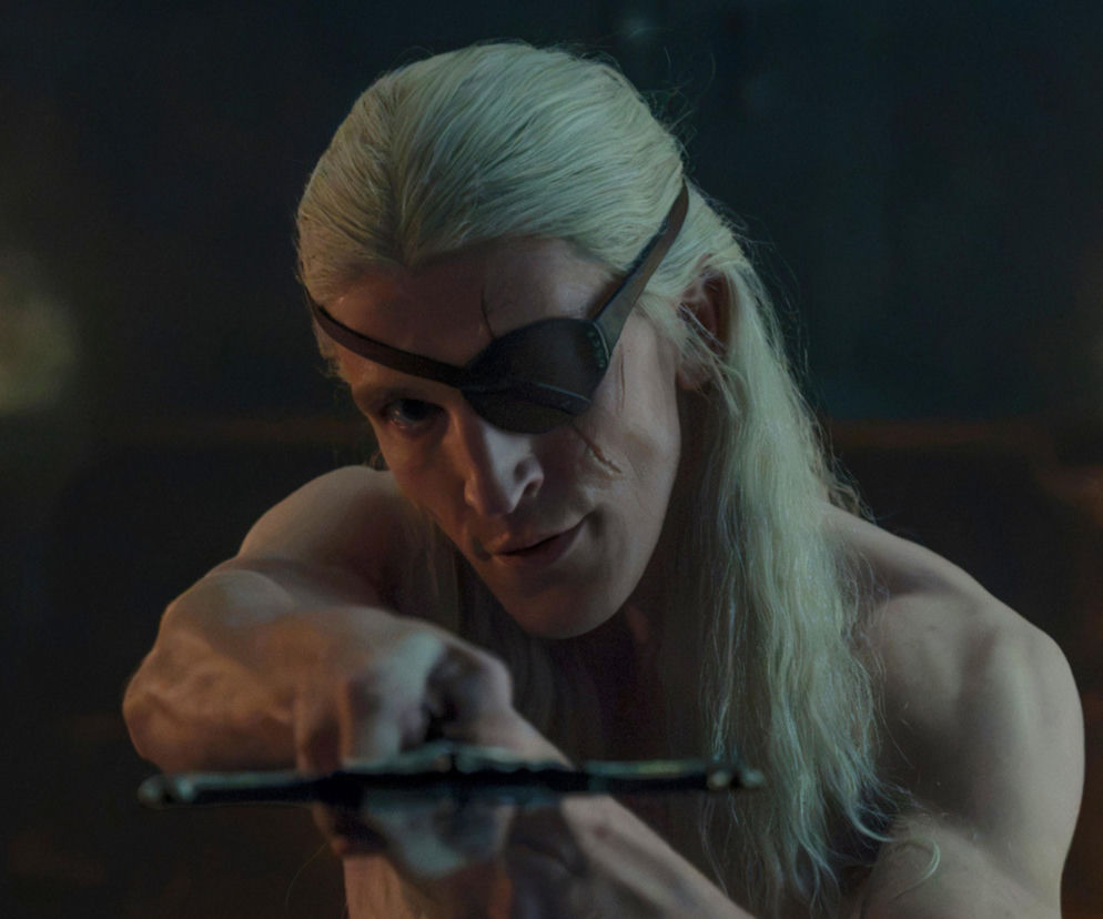 Aemond Targaryen z opaską na oku mierzy z miecza. O losach bohatera Rodu smoka przeczytasz na SE.