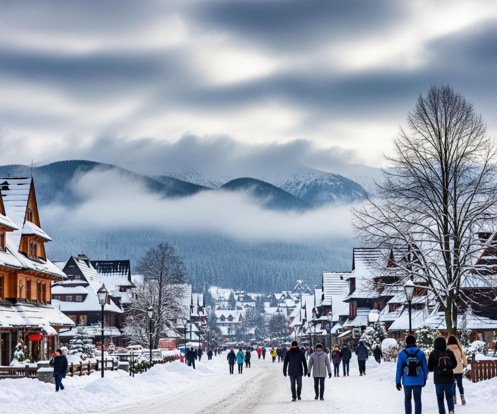 Ulicą, pokrytą warstwą śniegu i lodu, przechodzi wiele osób. Po obu stronach drogi rozciągają się drewniane, dwupiętrowe budynki o szpiczastych dachach, również pokryte obficie śniegiem, przypominające architekturę góralską. Za budynkami, w oddali, widać ośnieżone, ciemne góry, częściowo zakryte szarymi chmurami i mgłą, tworzącą pasma nisko nad szczytami. Na środku kadru, między budynkami, stoi nagie drzewo z rozgałęzionymi gałęziami, a cała scena rozgrywa się pod pochmurnym, zimowym niebem.