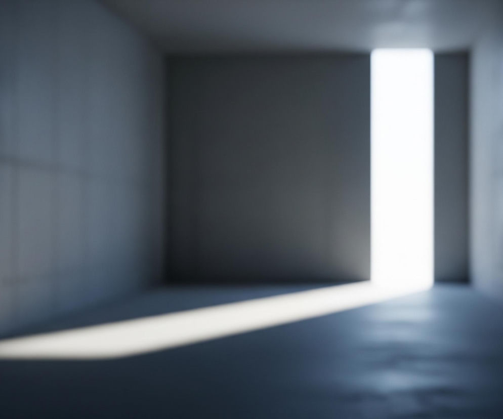 Ciemny, pusty korytarz lub tunel z betonu, oświetlony jasnym, pionowym pasem światła w oddali. Światło tworzy wydłużony, prostokątny cień na podłodze, prowadzący w stronę obserwatora. Ściany, podłoga i sufit są w odcieniach szarości i granatu, a cała scena jest nieostra, z rozmytymi krawędziami, co nadaje jej oniryczny charakter.