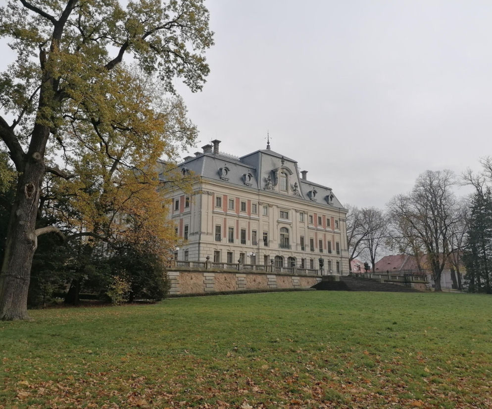 Zamek w Pszczynie widziany od strony parku z jesiennymi drzewami. O historii Perły Górnego Śląska przeczytasz w Eska Śląskie.