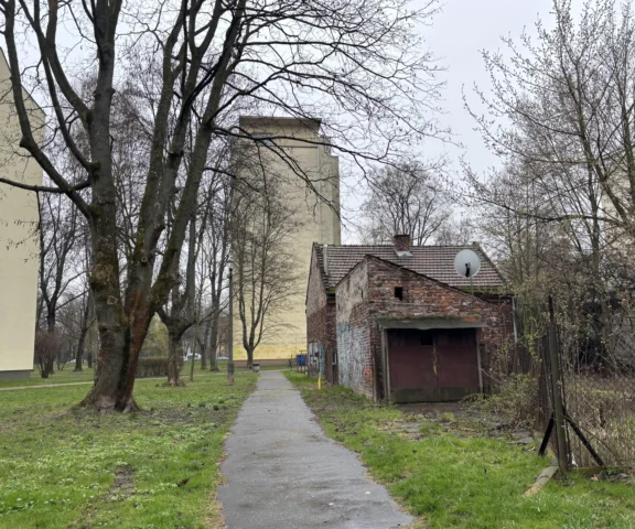 Ceglany wiejski domek ostał się wśród bloków. Osiedle Kolorowe 37 w Krakowie