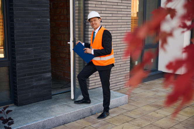 Inspektor przed wejściem do nowego budynku – Nadzór inwestorski