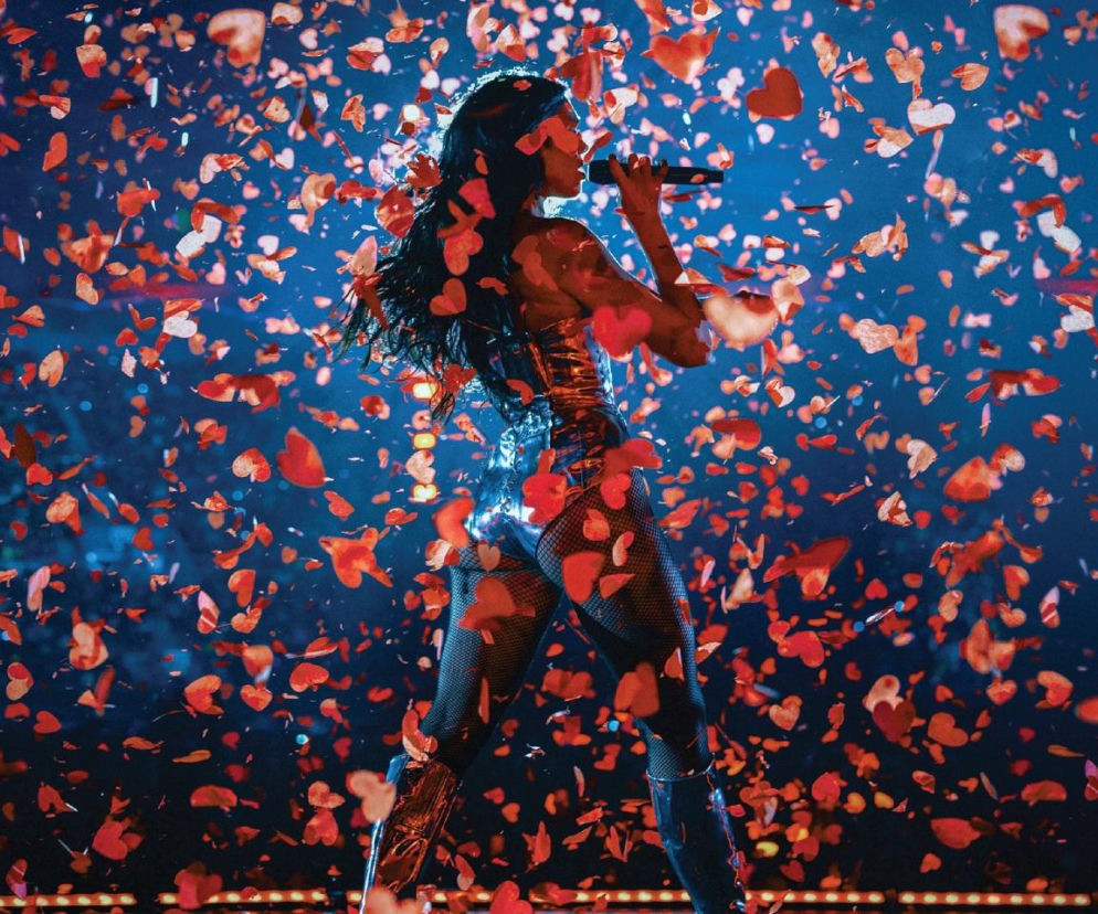 Dua Lipa śpiewa na scenie w deszczu czerwonych serc. O sukcesach Raye i Duy Lipy w streamingu przeczytasz na Eska.