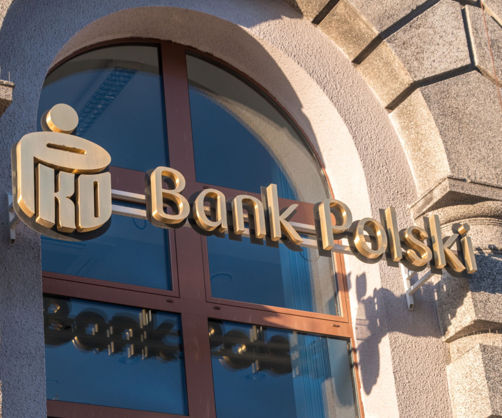 Złoty logotyp PKO Banku Polskiego na fasadzie budynku, symbolizujący bezpieczeństwo bankowości, które jest tematem ostrzeżeń przed oszustami. Więcej o zabezpieczeniach przeczytasz na Super Biznes.