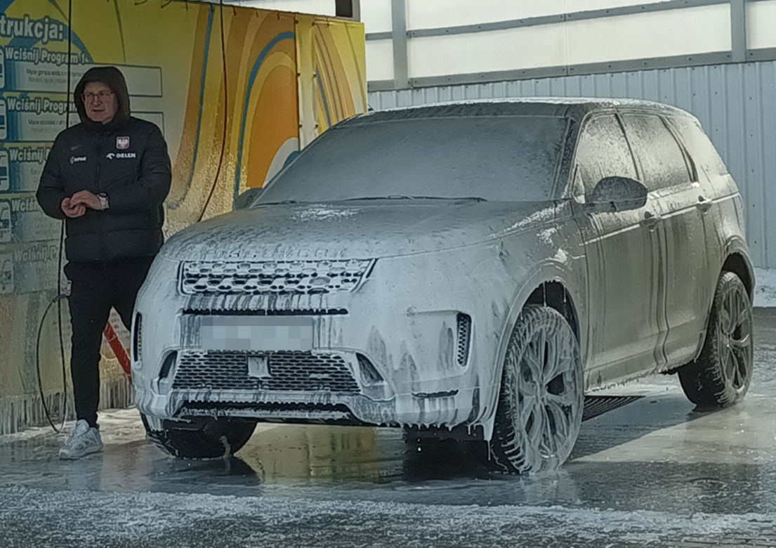 Czesław Michniewicz myje auto w stroju selekcjonera