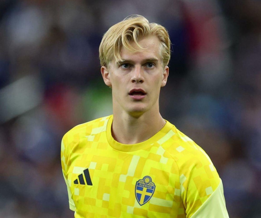 Portret Lucasa Bergvalla, szwedzkiego piłkarza, z blond włosami i niebieskimi oczami, ubranego w żółtą koszulkę reprezentacji Szwecji z logo Sverige, o którym przeczytasz więcej na naszym portalu.
