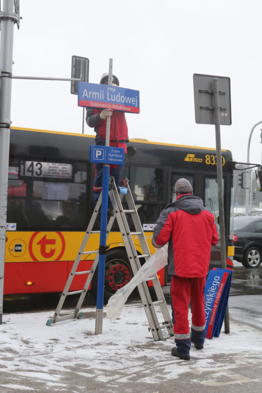 Dekomunizacja Warszawy. Zdejmowanie tablicy z Aleją Lecha Kaczyńskiego, zakładanie na powrót Armii Ludowej.