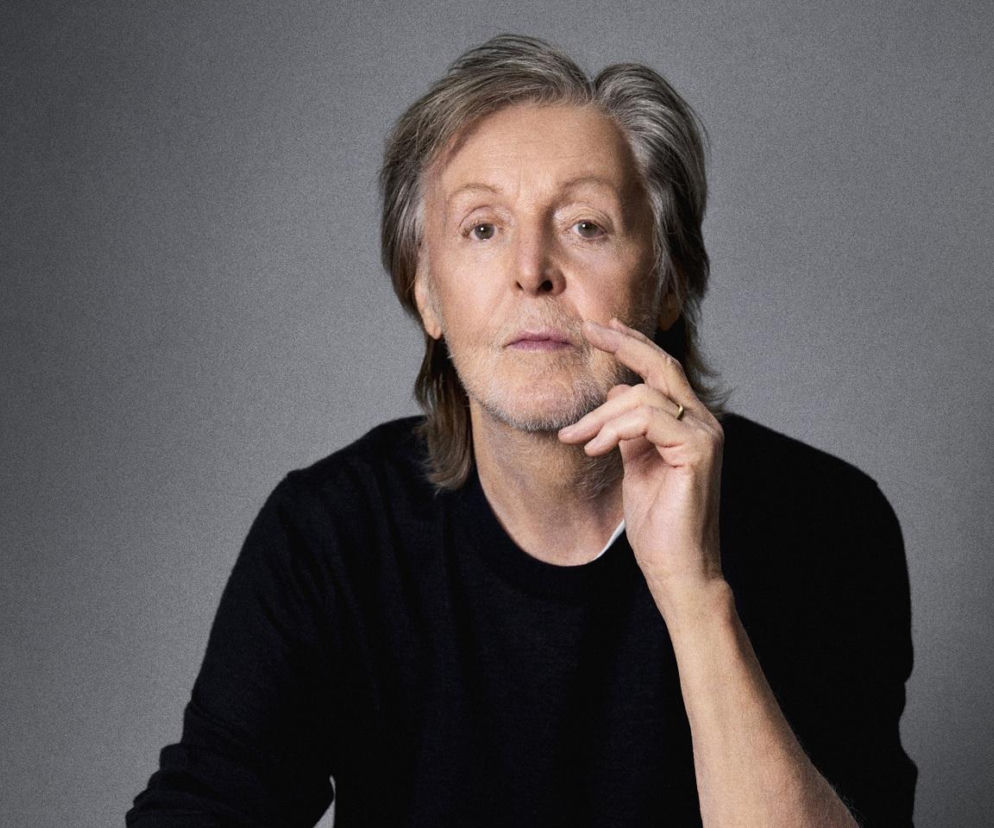 Muzyk Paul McCartney trzyma dłoń przy twarzy. O jego niezwykłych wspomnieniach z narodzin przeczytasz na EskaRock.