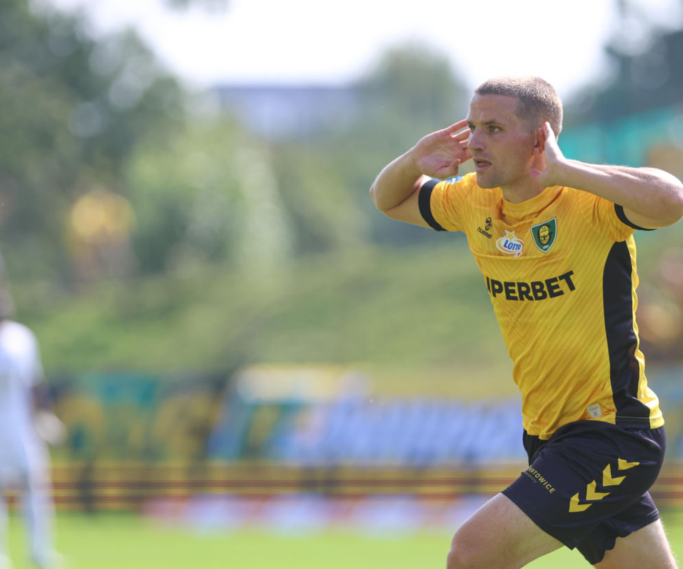 Piłkarz Adrian Błąd w żółtej koszulce GKS Katowice trzyma dłonie przy uszach. O jego chorobie czytaj w SE Supersport.