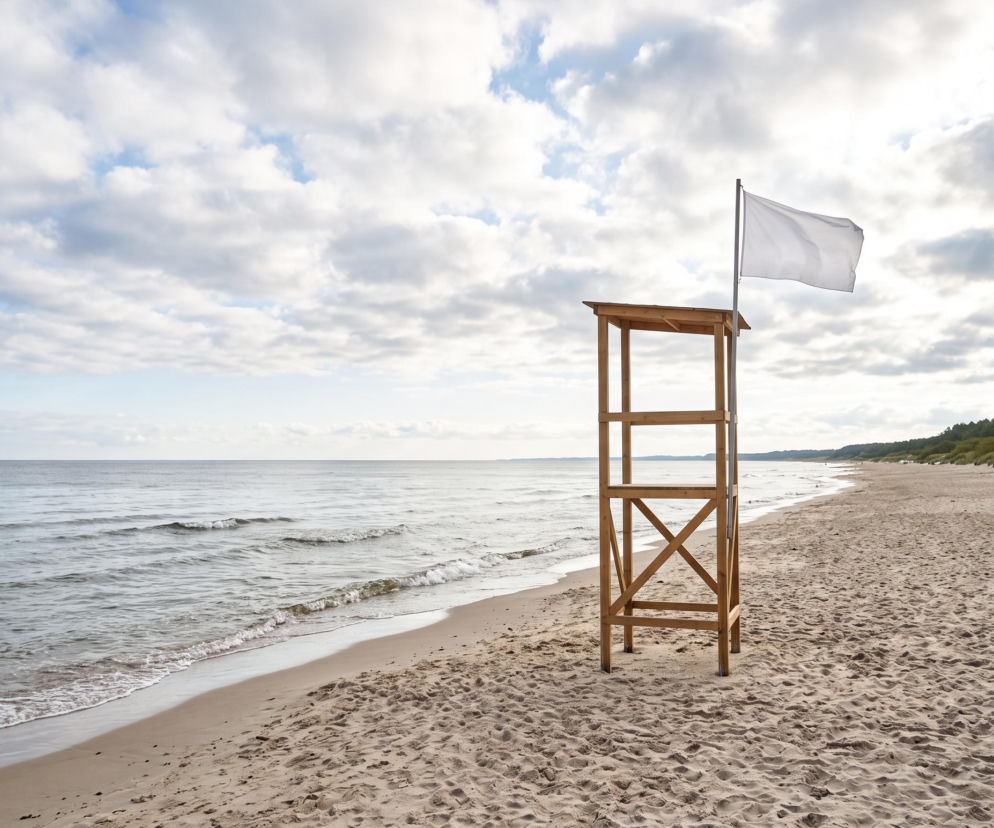 Wieża ratownicza z białą flagą na pustej plaży w Grzybowie. O warunkach nad morzem przeczytasz na SE Szczecin.