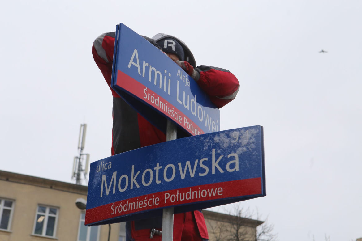 Dekomunizacja Warszawy. Zdejmowanie tablicy z Aleją Lecha Kaczyńskiego, zakładanie na powrót Armii Ludowej.