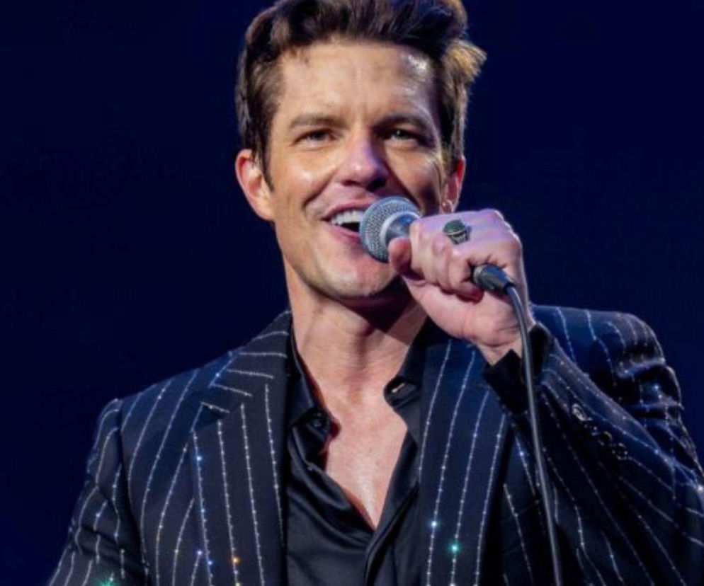 Brandon Flowers śpiewa do mikrofonu na koncercie. O jego planach zakończenia kariery przeczytasz na EskaRock.
