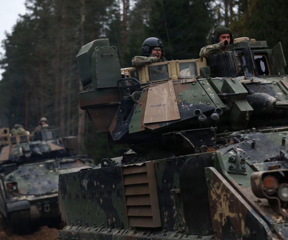 Żołnierze w transporterach opancerzonych Bradley na leśnej drodze. O obecności wojsk USA przeczytasz na SE Portal Obronny.
